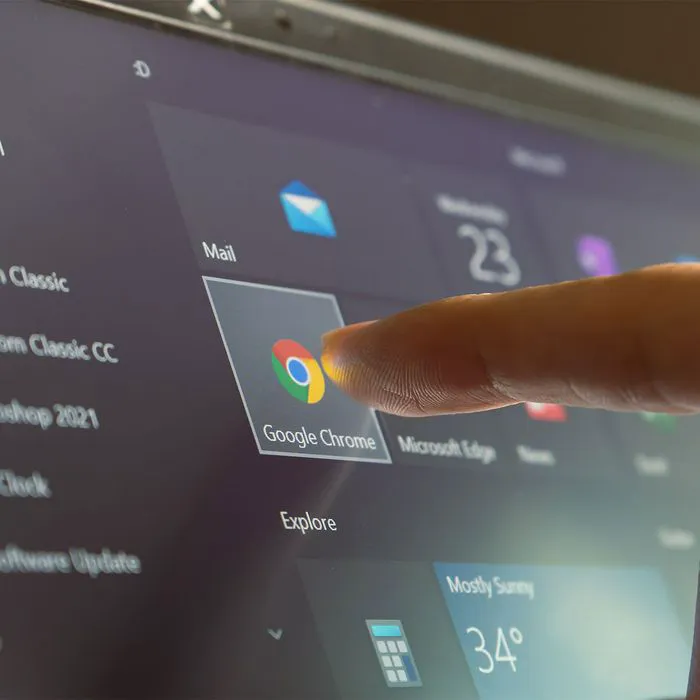 Finger touching Chrome app icon on touchscreen device