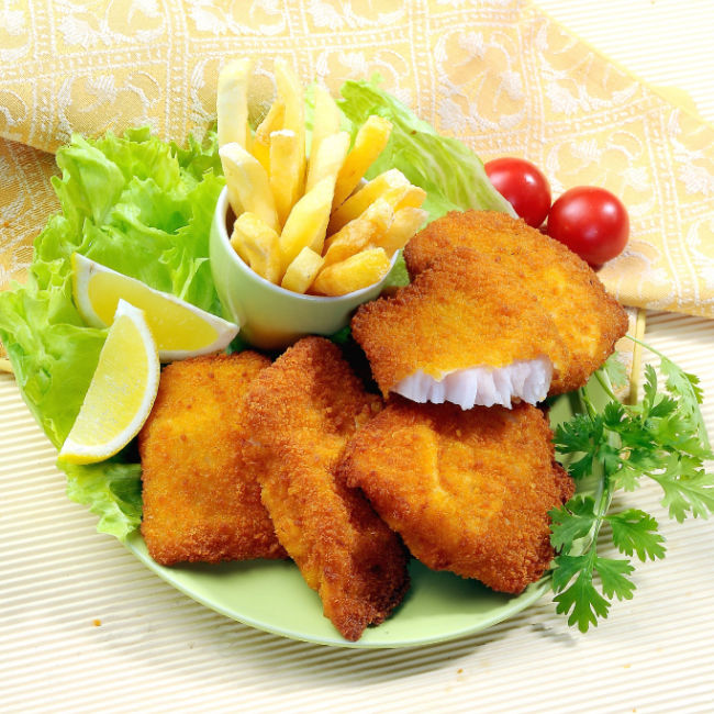 breaded fish patties plated with fries and lemon slices