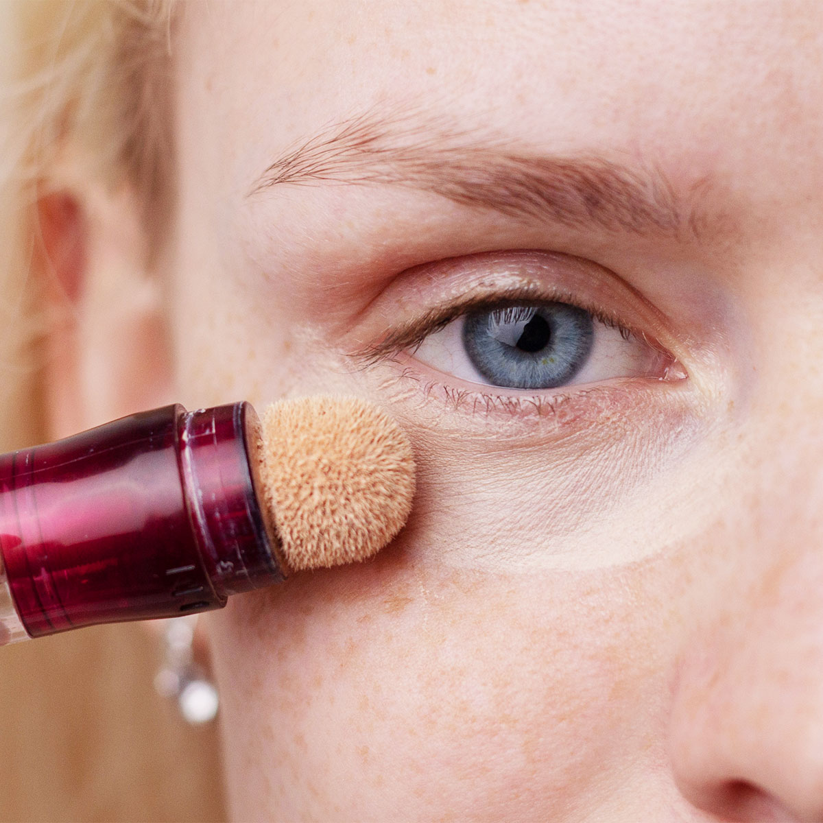 woman applying under-eye concealer under eyes dark circles