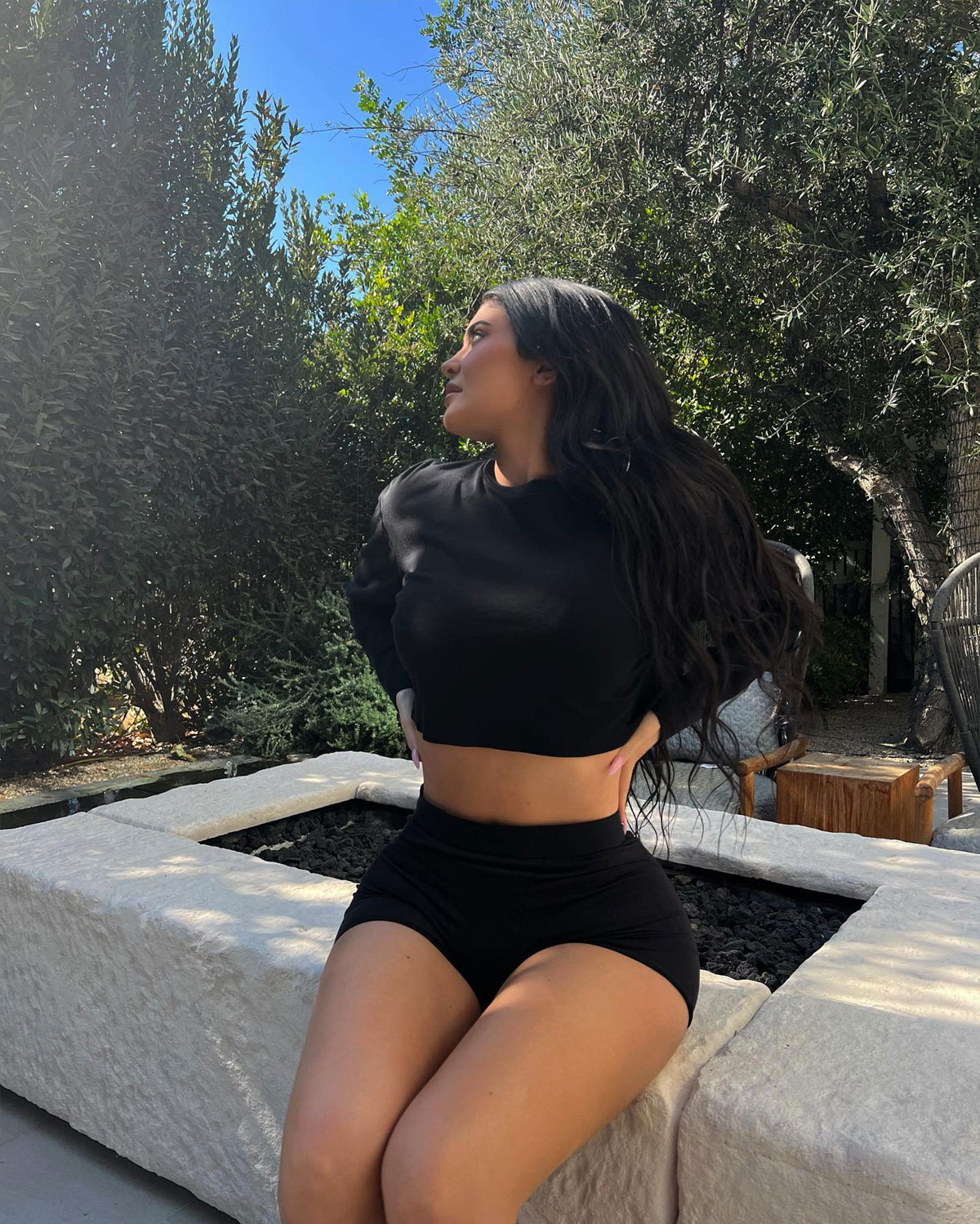 Kylie Jenner posing outside in crop top and bike shorts