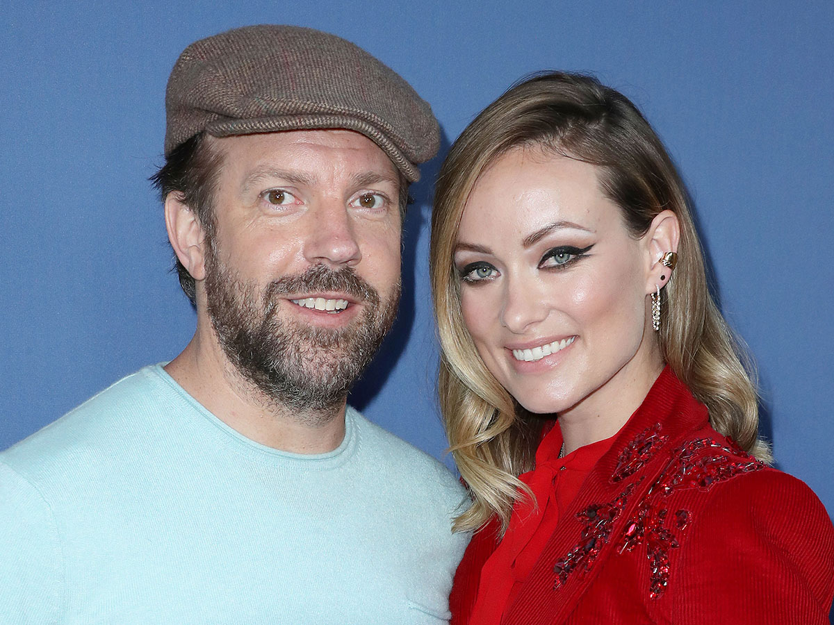 jason sudeikis hat blue tshirt olivia wilde red outfit dark eye makeup