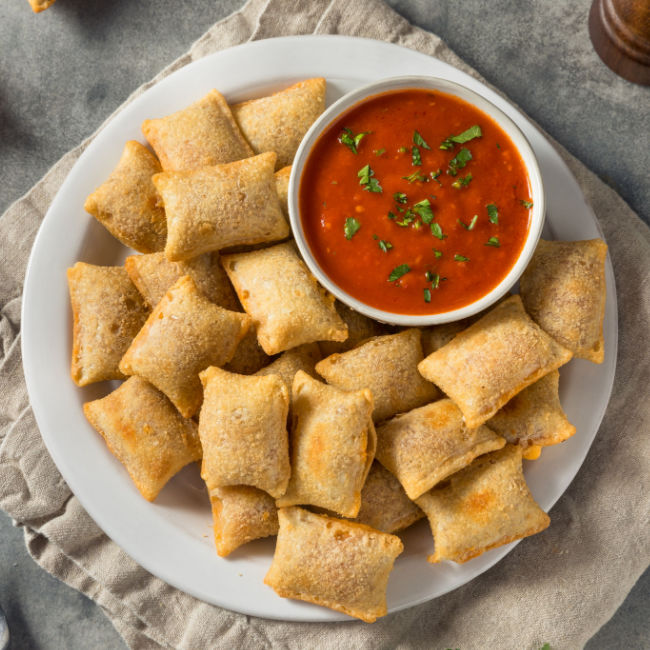 pizza rolls on plate with small bowl of marinara