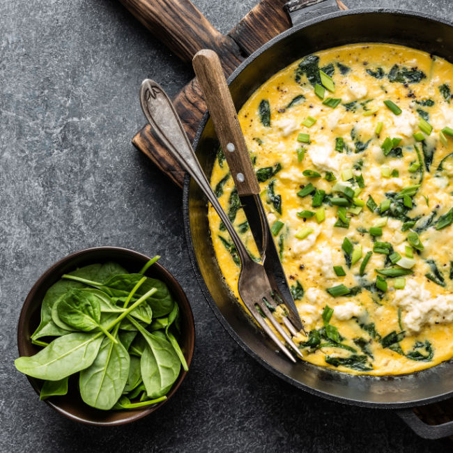 pan with eggs and spinach in it
