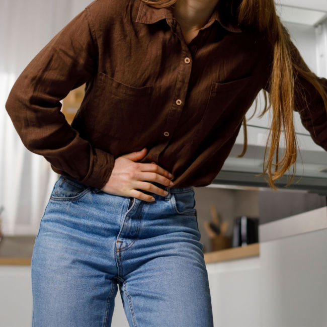 hungry woman holding her stomach in kitchen