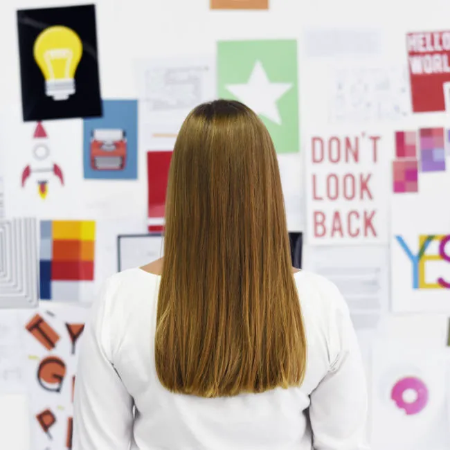woman looking at wall full of encouraging images and statements