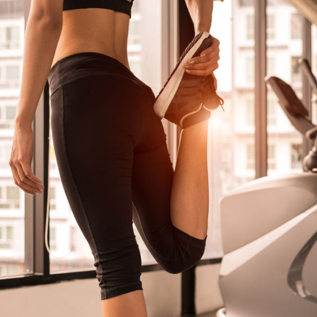 woman-stretching-leg-at-gym