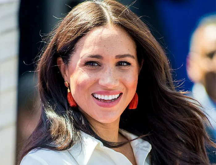 Meghan Markle hair down white shirt red earrings
