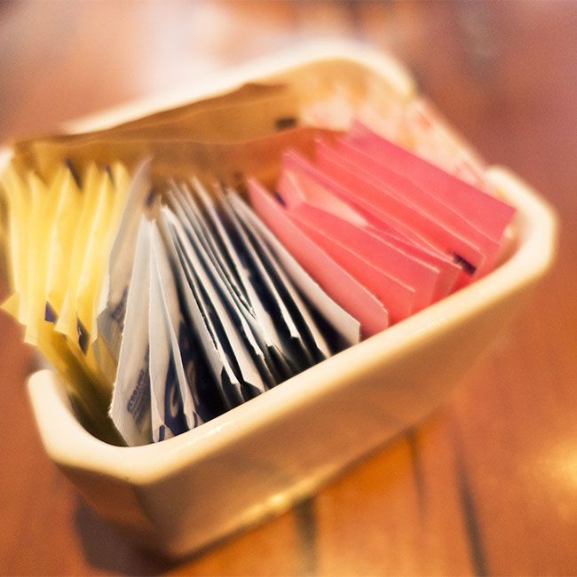 packets of artificial sweeteners in plastic container