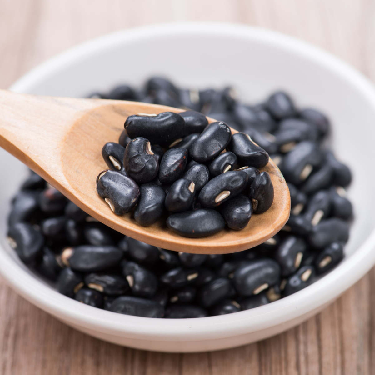 bowl of black beans with wooden spoon