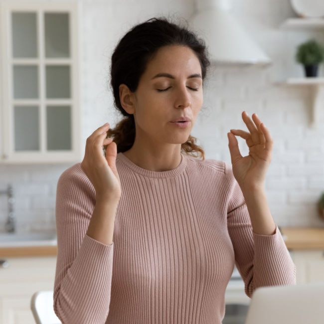 woman breathing deeply in kitchen