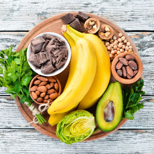 display of magnesium-rich foods like banana, avocado, brussels sprouts, and nuts