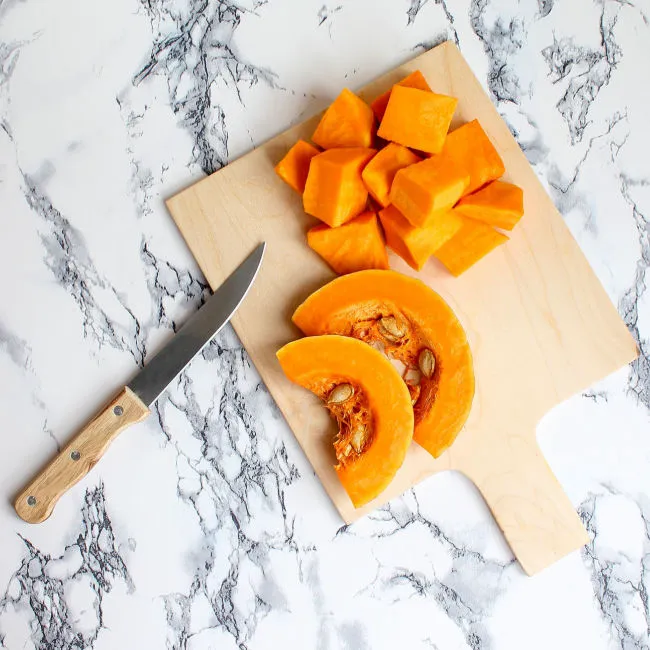 chunks of cut up pumpkin on cutting board