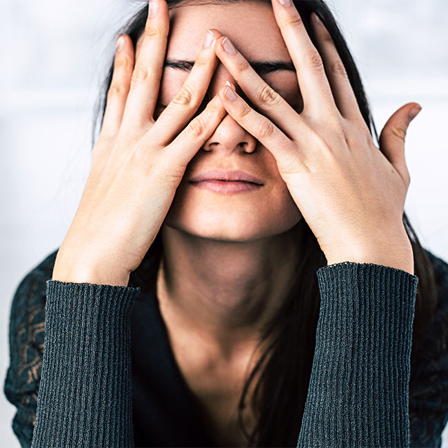 woman looking stressed out with hands on face
