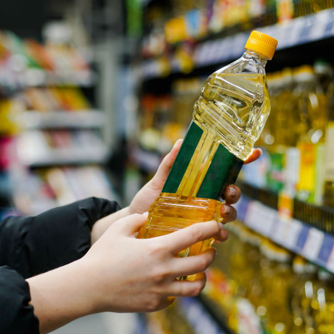 woman choosing oil in grocery store