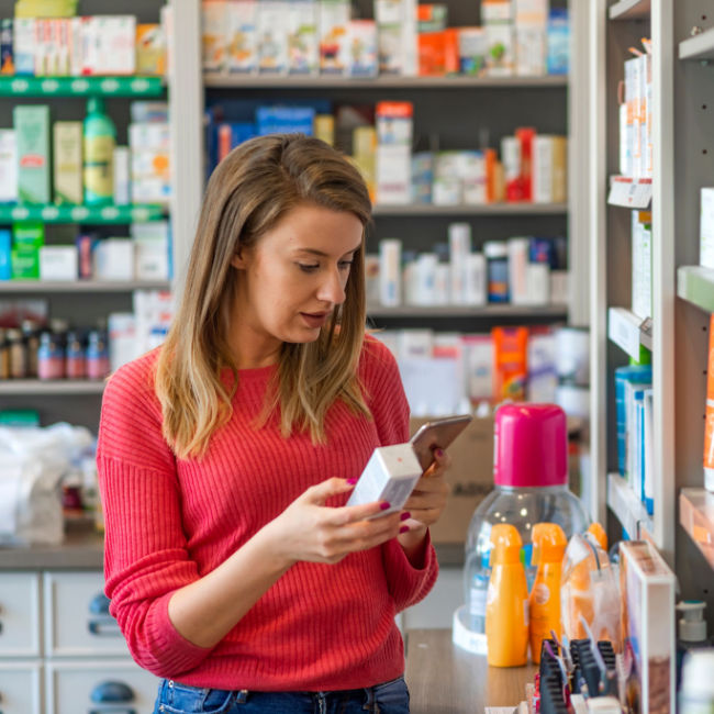 woman choosing probiotic supplement in store