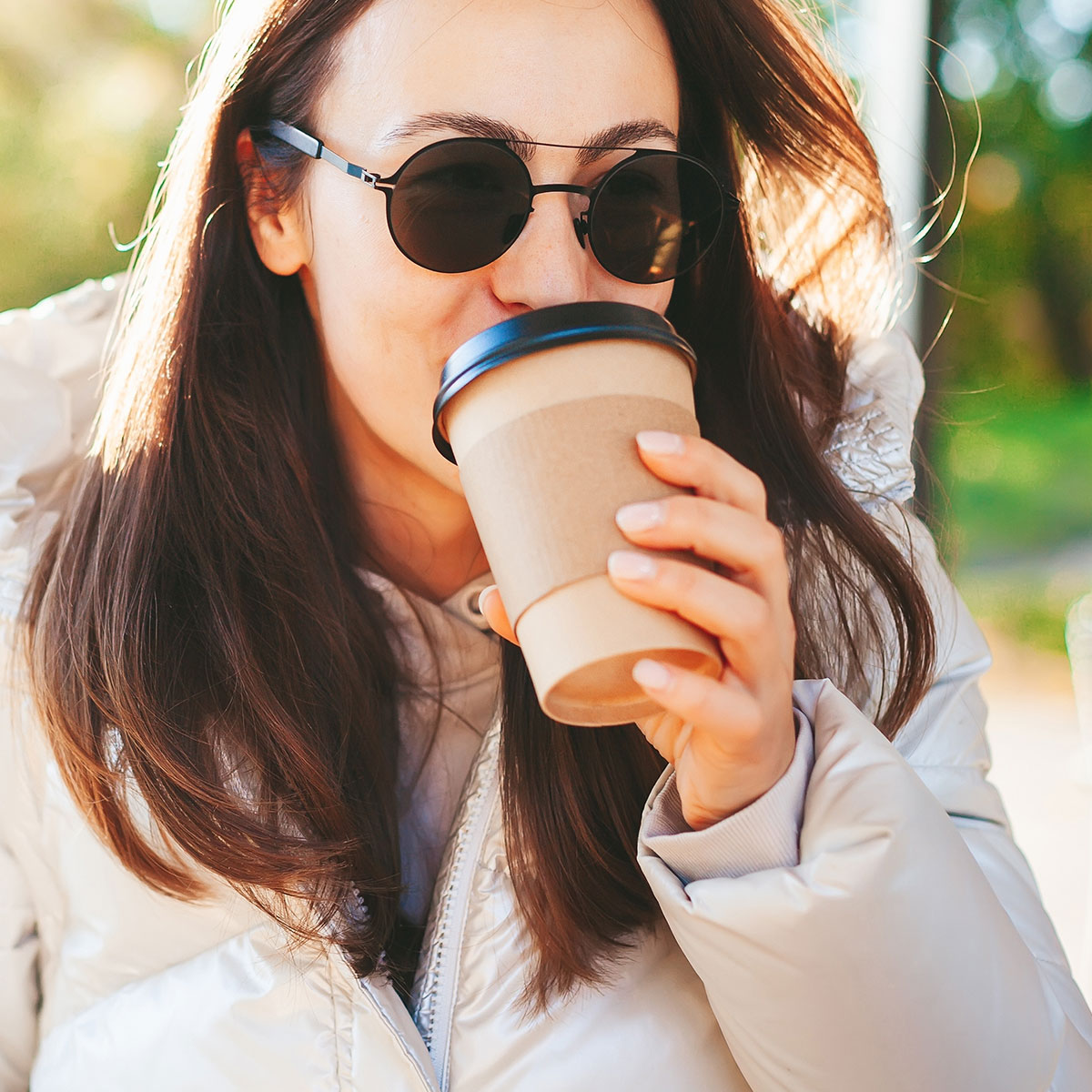 woman drinking to-go coffee outside