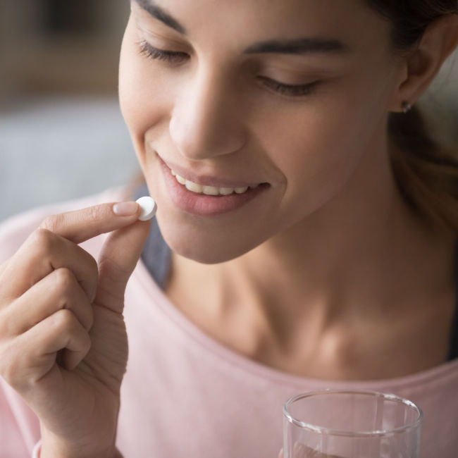 woman taking probiotic pill