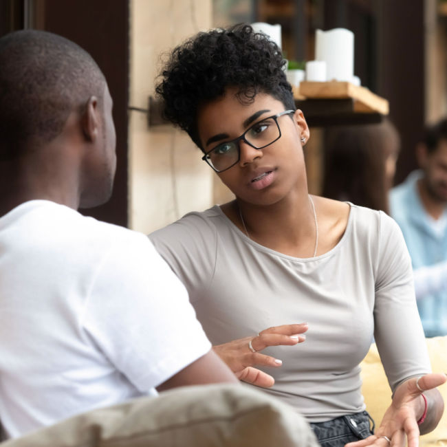 woman having serious discussion with man on couch