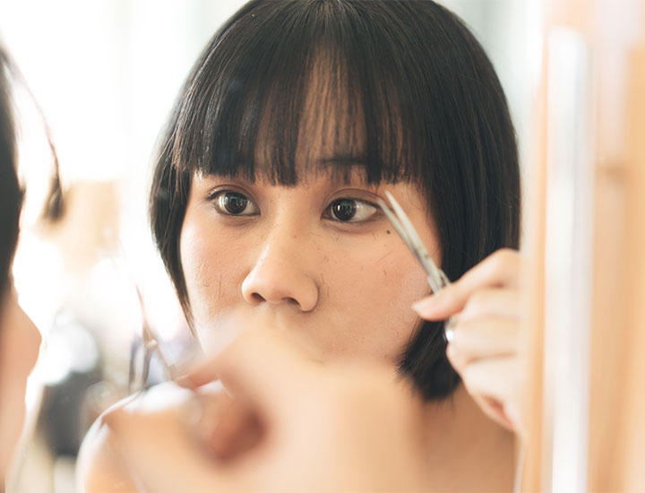 woman-trimming-blunt-bangs