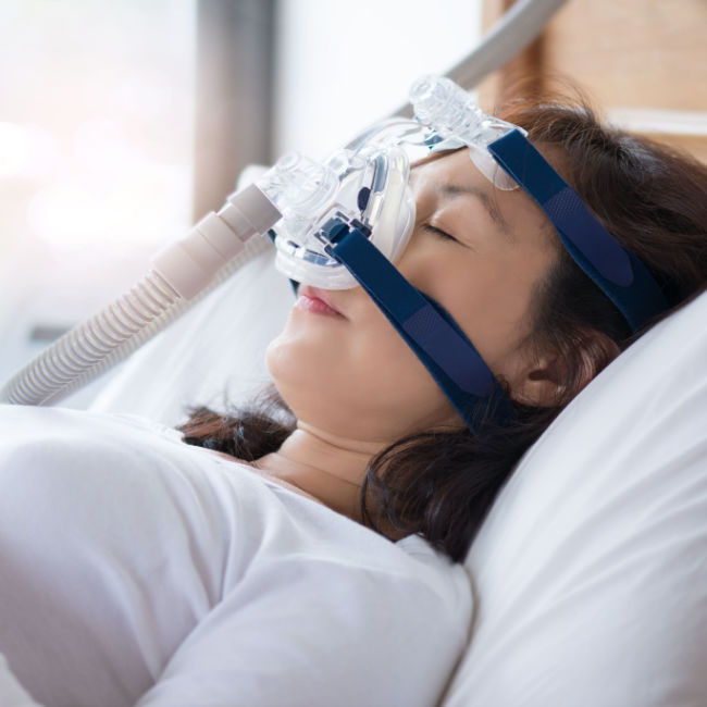 woman sleeping with sleep apnea mask