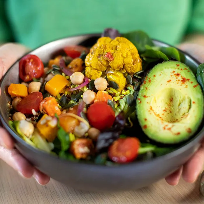 Buddha bowl filled with vegetables, avocado, and chickpeas.