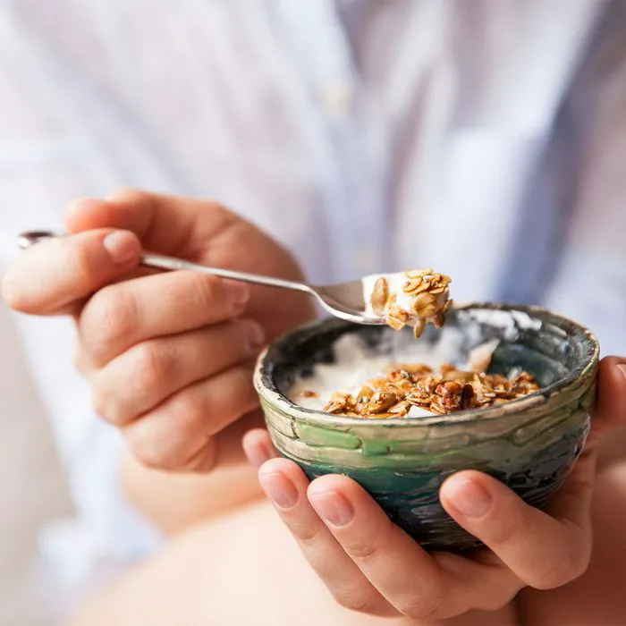 Bowl of yogurt topped with granola and fresh berries.
