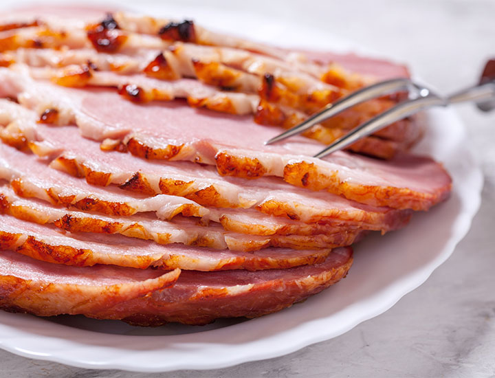 Plate of Christmas ham on a table.