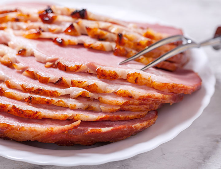 Plate of Christmas ham on a table.