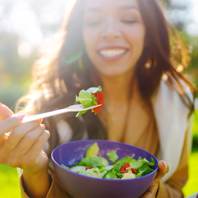 woman smiling eating salad