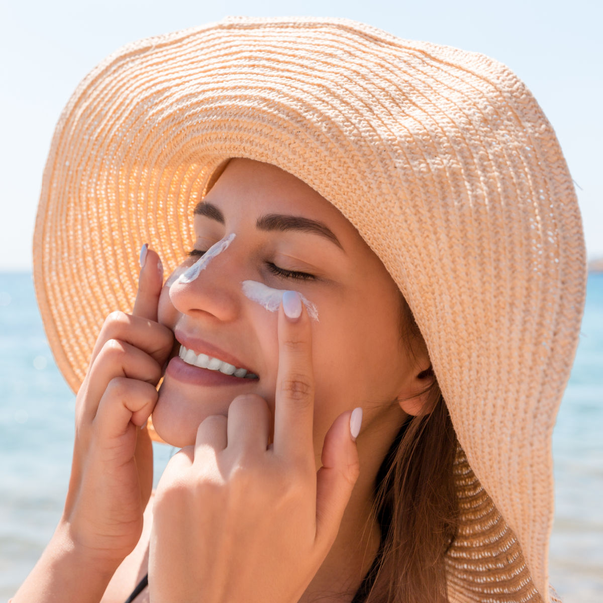 Woman putting on sunscreen.