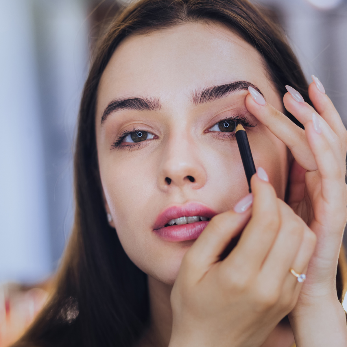 Woman applying eyeliner.