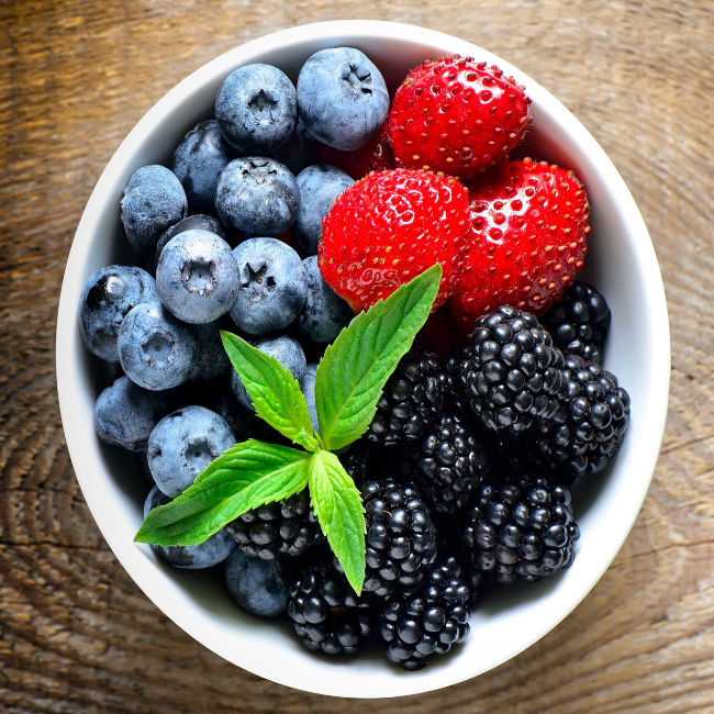 bowl filled with strawberries, blueberries, and blackberries
