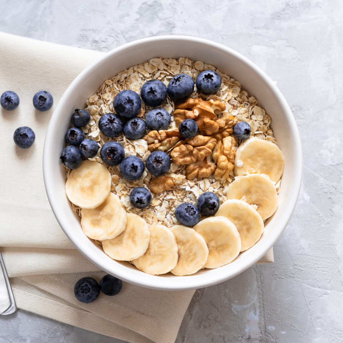 bowl of oatmeal topped with nuts and fruit