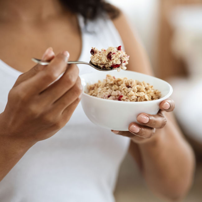 woman eating bowl of oatmeal