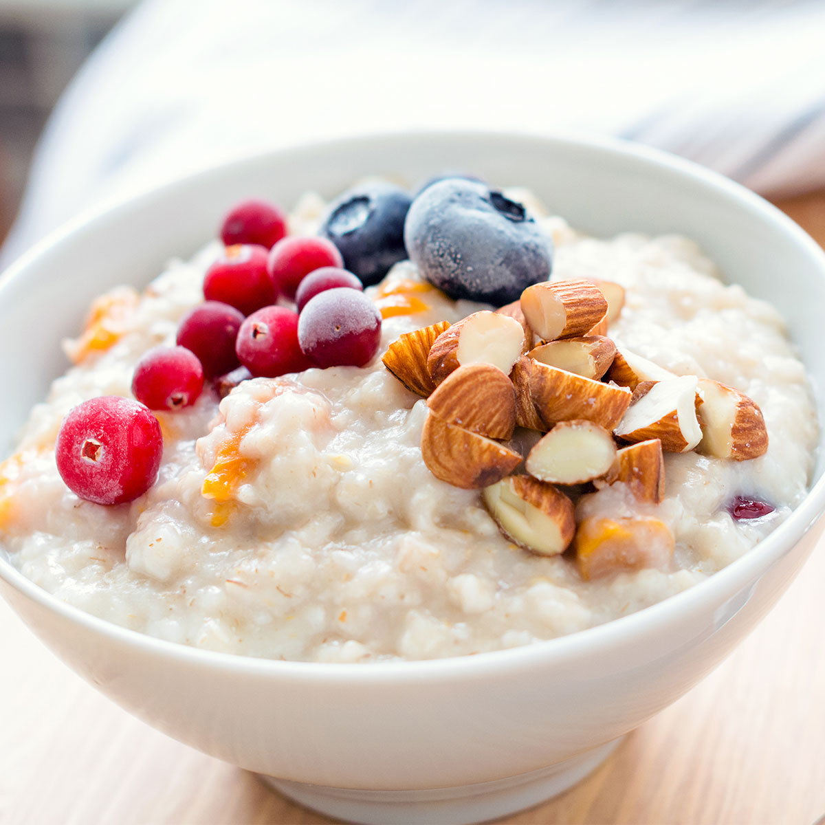 bowl of oatmeal topped with nuts and berries