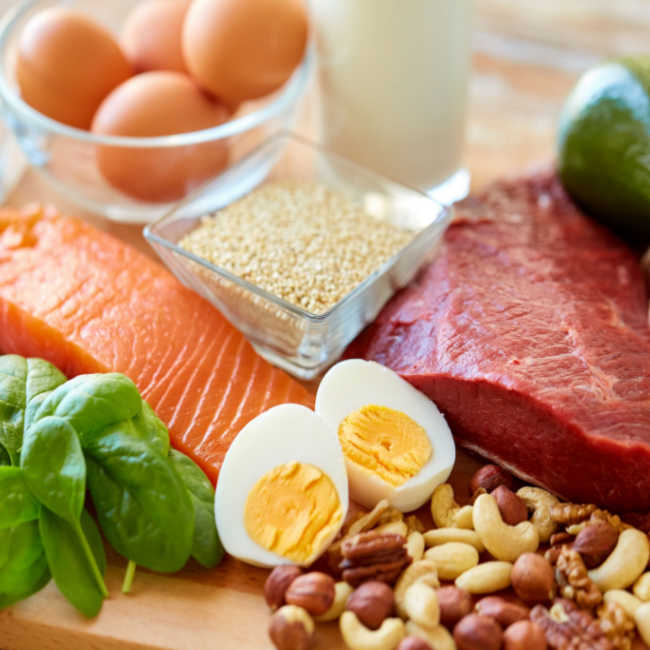various sources of protein such as eggs, nuts, fish, and beef displayed on a table