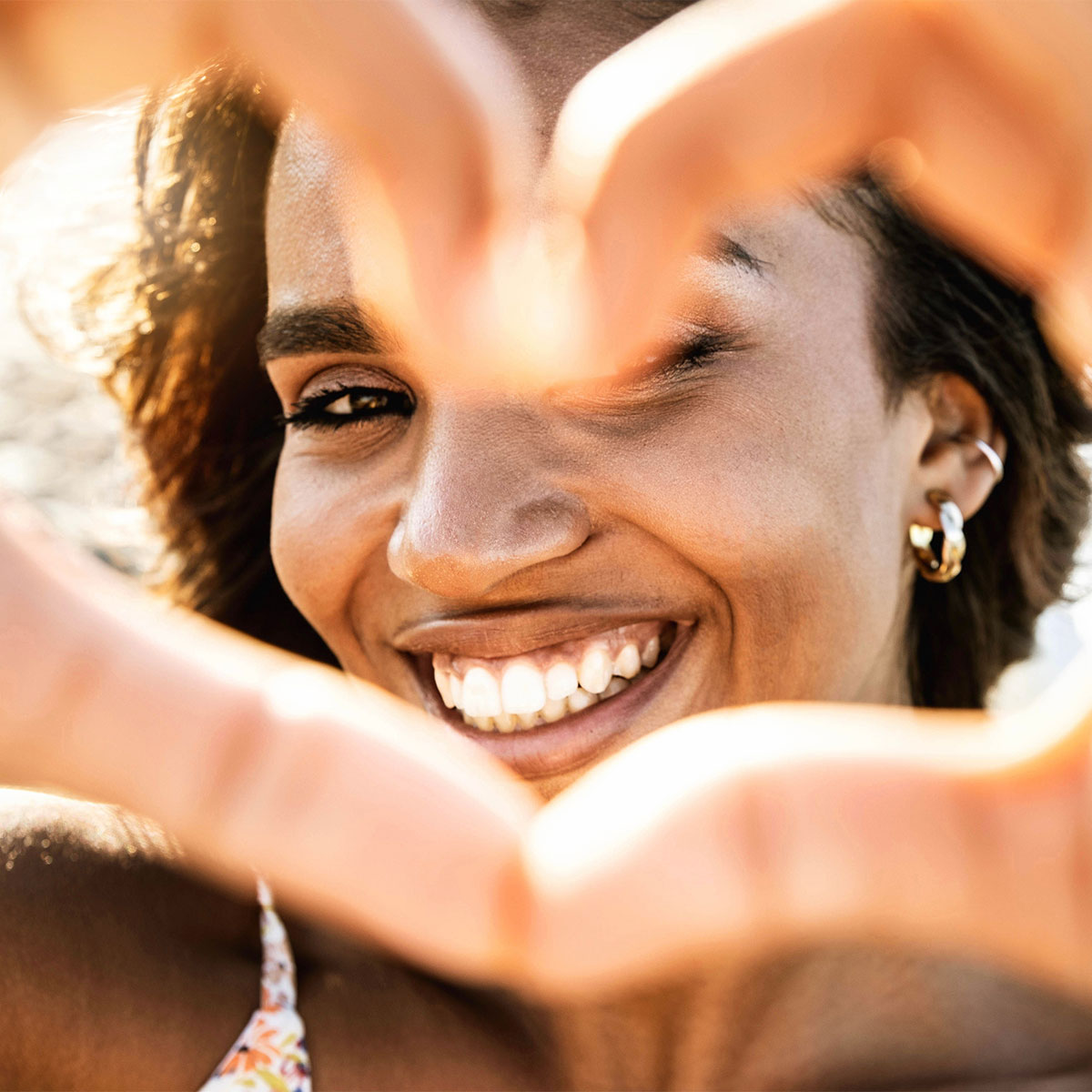 woman smiling and making a heart with her fingers