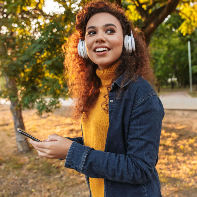woman walking outside with headphones on in the fall