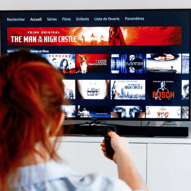 woman with red hair scrolling through amazon prime on tv