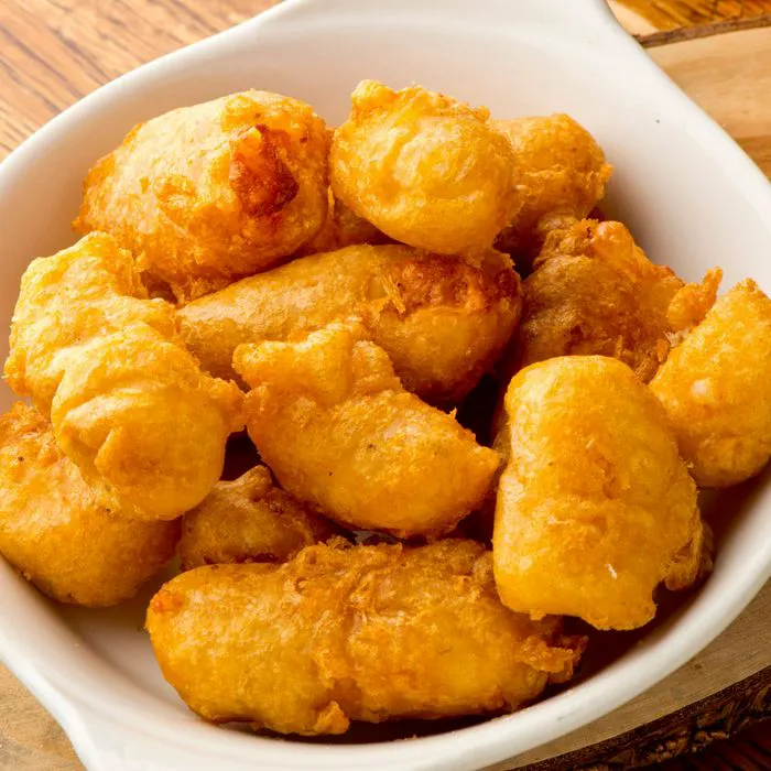 Freshly made cheese curds on a wooden platter