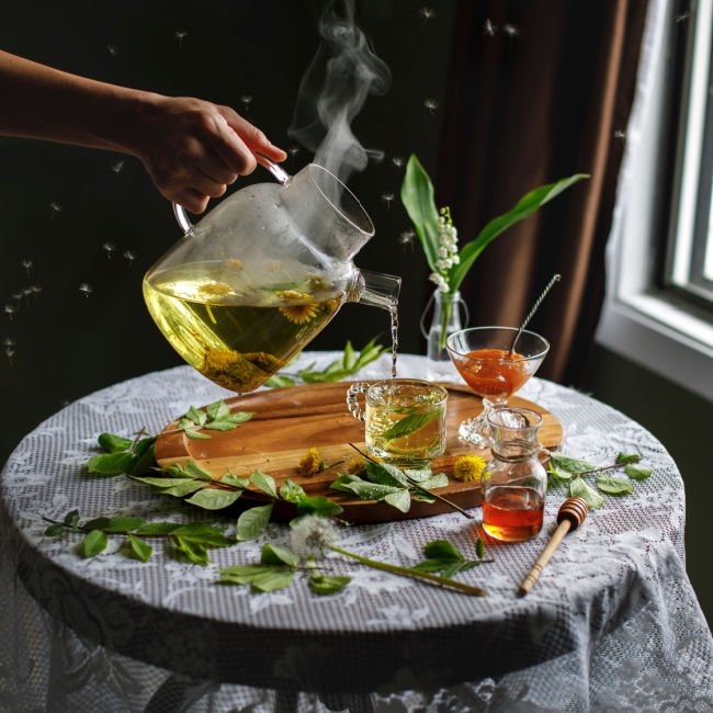 dandelion tea pouring into cups on round table