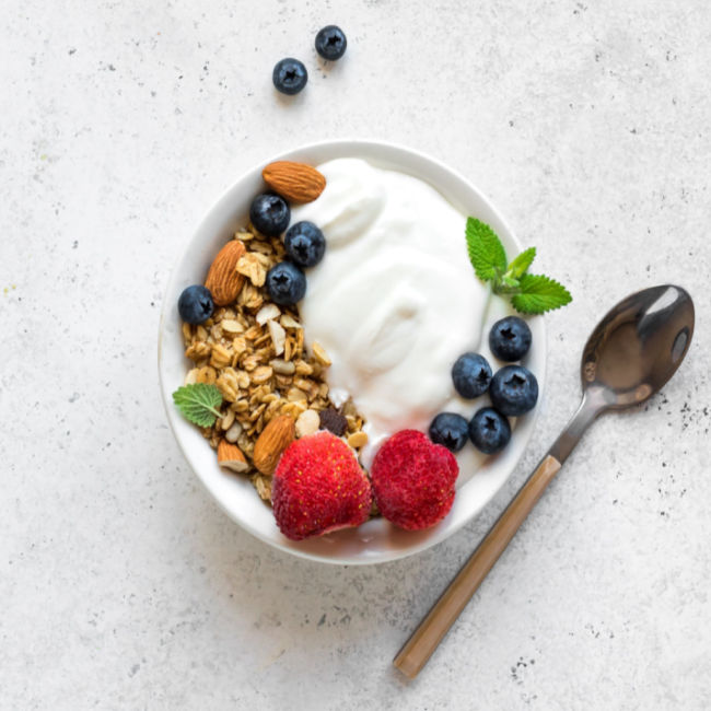 bowl of greek yogurt topped with berries and granola