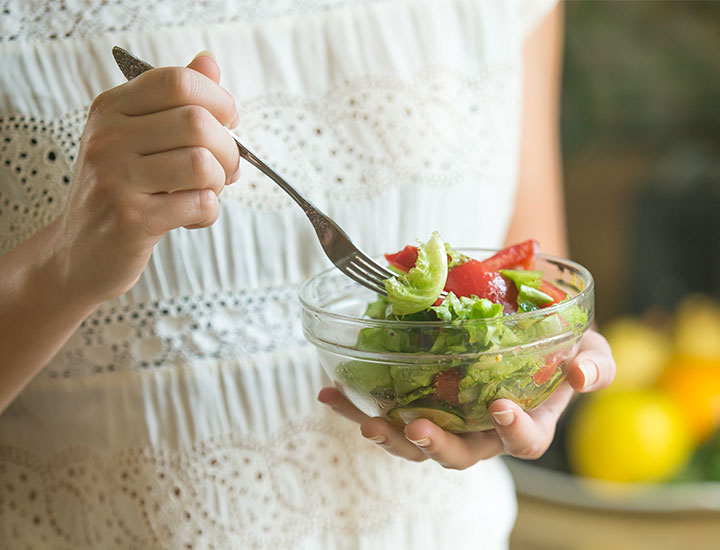 Woman eating salad.