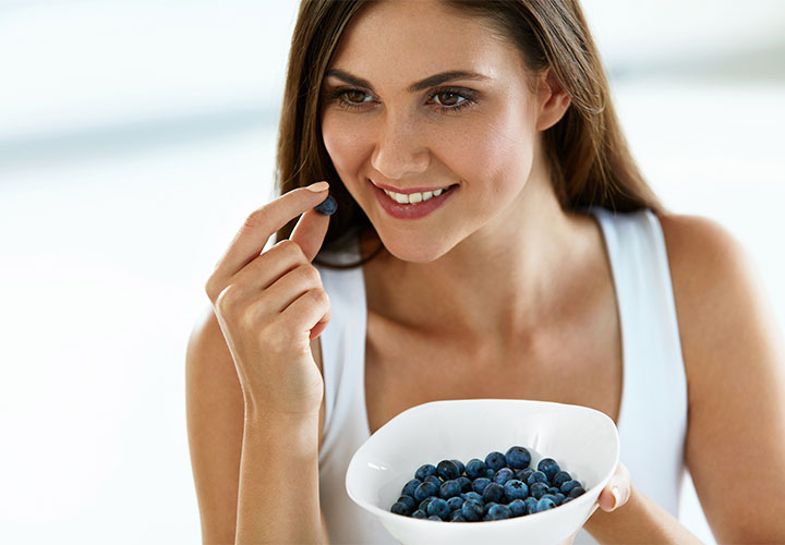 Woman eating blueberries.
