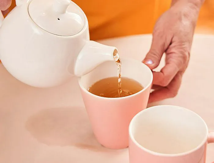 Woman pouring a pot of tea