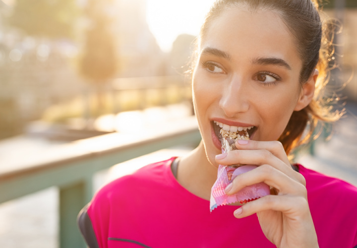 Woman eating protein bar.