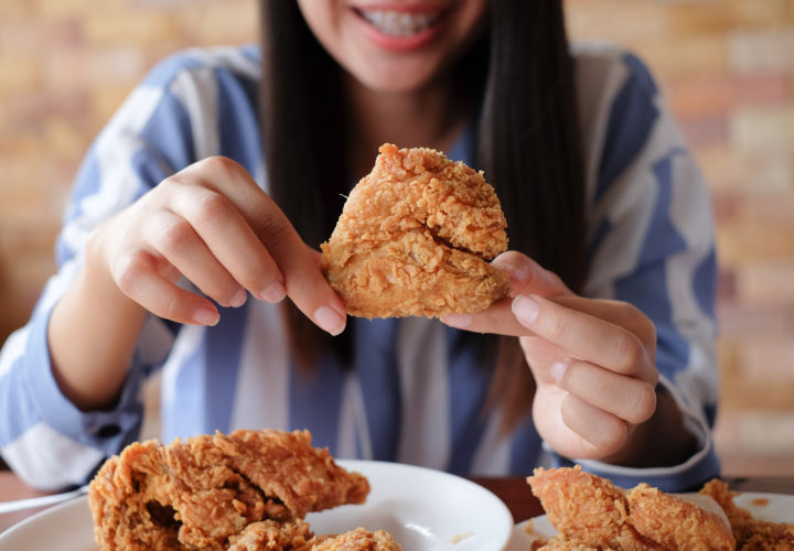 Woman eating fried chicken.