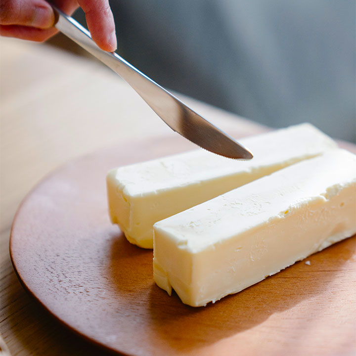 knife cutting into two sticks of butter