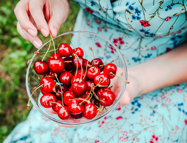 Woman eating cherries.