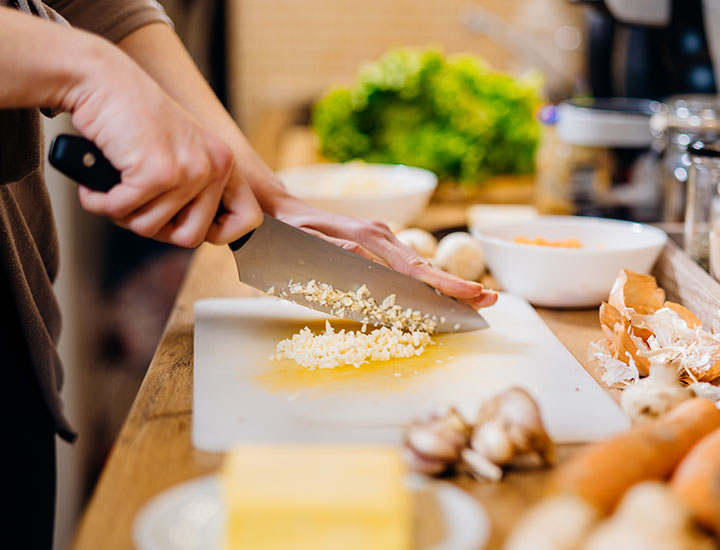 Woman cooking with garlic.